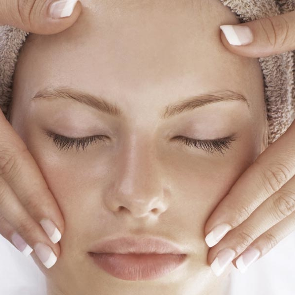 Woman lying on back getting a Zenergy facial and cheek massage