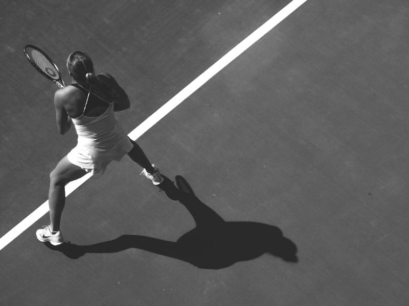 female tennis competitor readies to return a shot